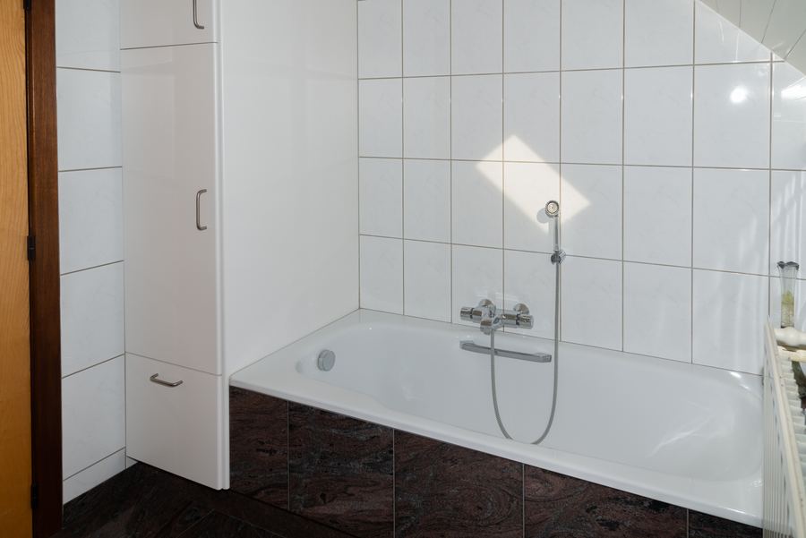 Ligbad met handdouche in de badkamer boven