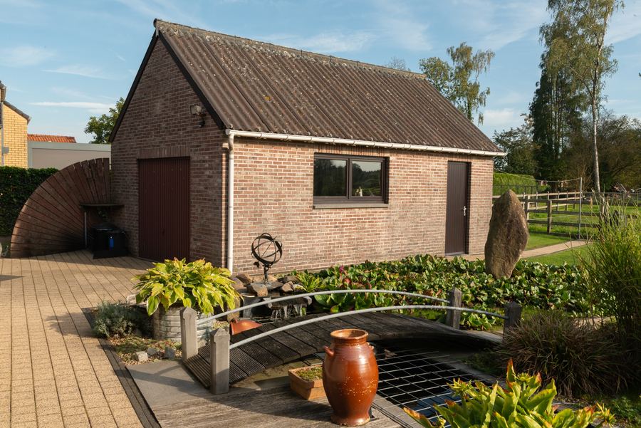Het vrijstaande bijgebouw, met de vijver op de voorgrond