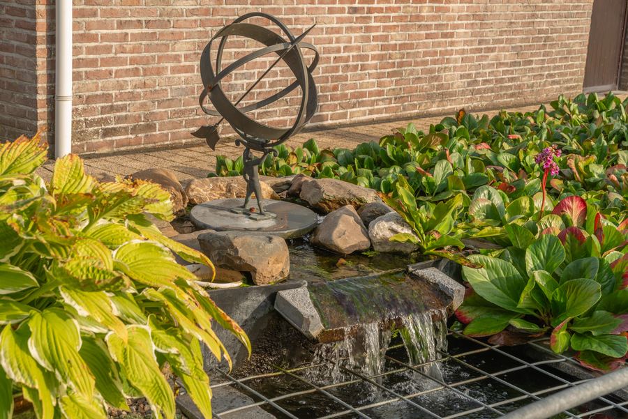 Het watervalletje met zonnewijzer, naast het terras