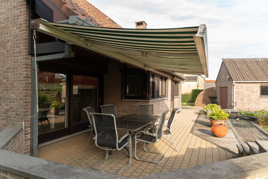 Het terras kijkt uit over de tuin en de vijver